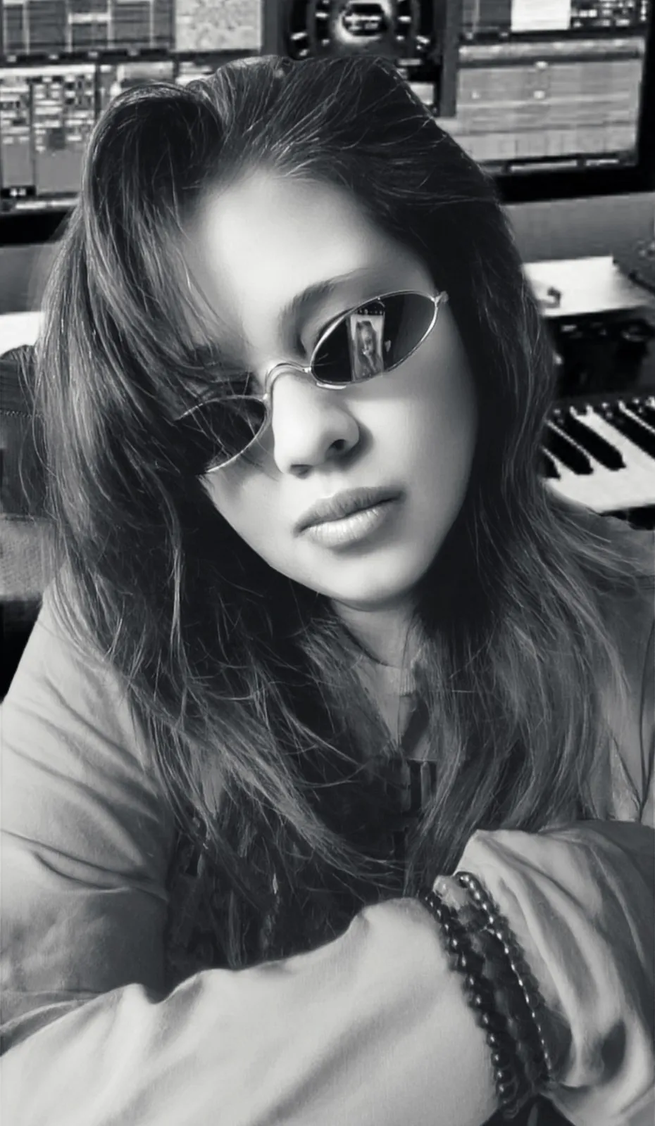 Anjalts in sunglasses beside a keyboard, black and white